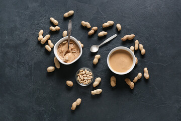 Tasty peanut butter with nuts on dark background