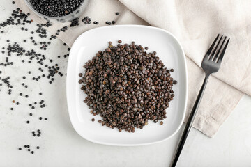 Plate with tasty cooked lentils on white background