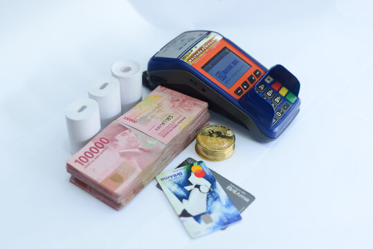 pile of hundred thousand rupiah banknotes, BANK BRI credit cards and bitcoins as well as an EDC (ELECTRONIC DATA CAPTURE BANK BRI) machine, photo taken on June 15, 2021 in city of Lumajang, indonesia