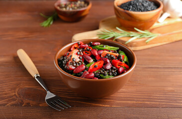 Bowl with tasty cooked lentils and vegetables on table