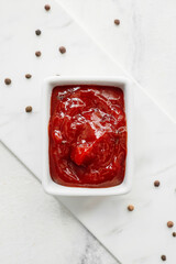 Bowl with tasty barbecue sauce on light background