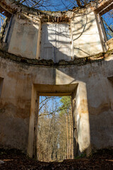 Fototapeta na wymiar View through a holes for doors and windows in an abandoned ruin in the woods
