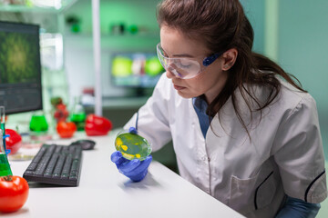 Pharmaceutical researcher analyzing solution test from petri dish for developing medical expertise....