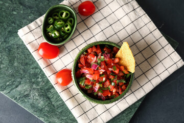 Bowl of tasty Pico de Gallo salsa on table - obrazy, fototapety, plakaty
