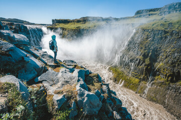 Woman on the cliff of Dettifoss most powerful waterfall in Europe, Iceland