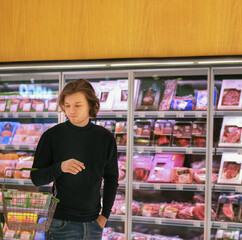 man purchasing a packet of meat at the supermarket.