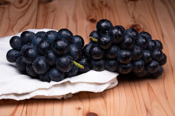 large grapes on a cloth on a black background.
A variety called Nagano Purple
