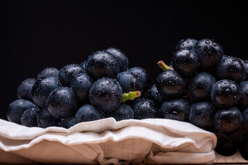 large grapes on a cloth on a black background.
A variety called Nagano Purple