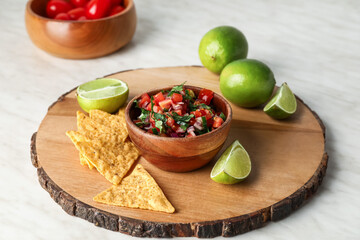 Bowl of tasty Pico de Gallo salsa and nachos on table