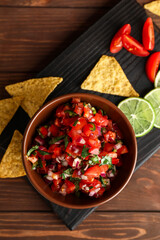 Bowl of tasty Pico de Gallo salsa on table