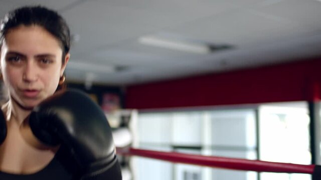 Fighter woman fist close up - boxer strikes into the side of the camcorder. Spectator video boxing.