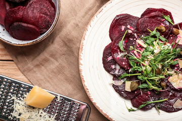 Plate with delicious beetroot carpaccio on wooden table