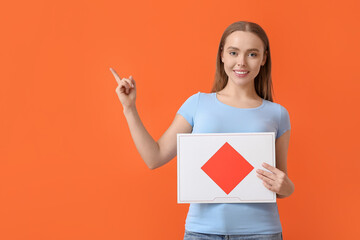 Young woman with letter pointing at something on color background