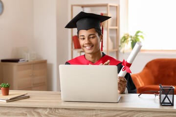 Happy African-American student on his graduation day at home. Concept of online education