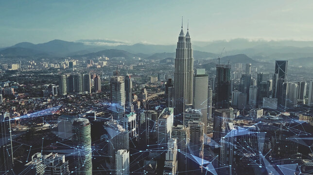 Digital network connection lines of Kuala Lumpur. Financial district and business centers in smart urban city in Asia. Skyscraper and high-rise buildings at night.