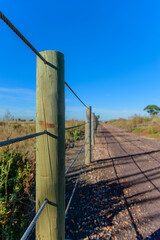 Fototapeta premium Cable fence running along gravel road