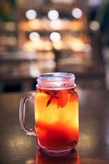Close up of red drink non-alcoholic mulled wine with a straw on the background of the cafe interior, order for one