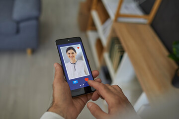 Love online concept. Closeup man pressing red heart button and giving a like to pretty smiling young woman's photo on social media website or mobile dating app. Hands holding cell phone in close up