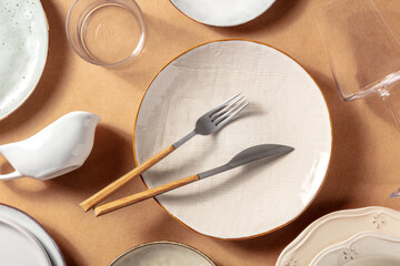 Modern tableware, overhead flat lay shot. Trendy plates, glasses, and cutlery, top view. Elegant dinnerware - obrazy, fototapety, plakaty