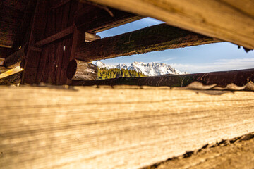 Mountain view through planks of a cabin