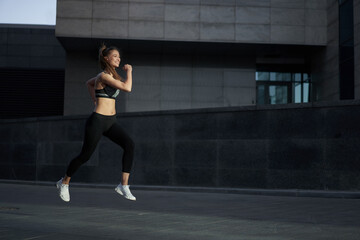 Obraz premium Woman running urban city street background