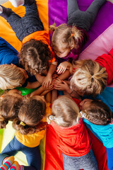 Cheerful children playing team building games on a floor - obrazy, fototapety, plakaty