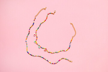 Assorted Waist Beads Belly Chain with little beads perler beads on pink background, perfect for...