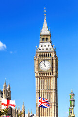 Fototapeta na wymiar Big Ben with flag of England and United Kingdom in London against blue sky.