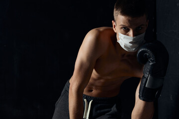 guy in medical mask athlete nude torso bodybuilder black background