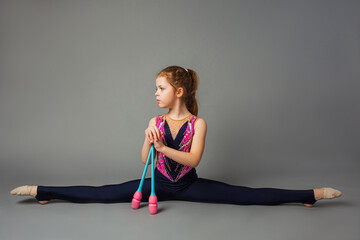 The little girl gymnast is posing with instruments