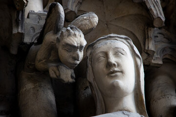 Slow travel in Paris - finding the little things: Figures on a church facade depicting a woman...
