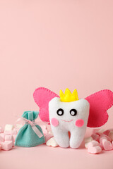 Cute toy for Tooth Fairy Day as funny smiling cartoon character of tooth fairy with crown, wings on pink background, copy space flyer, concept children milk toothless, funny toy, handmade felt diy - 439804199