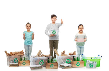 recycling, waste sorting and sustainability concept - smiling children with with plastic and glass bottles, papers garbage and metal tin cans in boxes showing thumbs up over white background