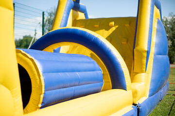 Inflatable obstacle course for fun. Inflatable structure in the park. - obrazy, fototapety, plakaty