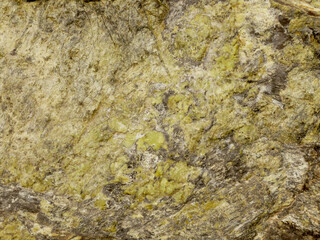 The texture of the red-colored stone is shot close-up. Background with stone texture. Stone layers, cracks in the stone. Green stone texture. Serpentine. 