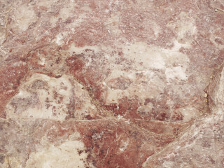 The texture of the red-colored stone is shot close-up. Background with stone texture. Stone layers, cracks in the stone. Yellow-red.