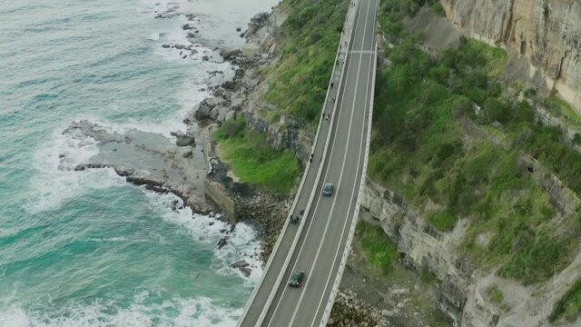 Highway bridge over the ocean and next to cliffs. 