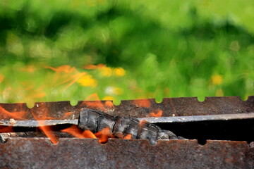 Empty grill grate and fire flame. Fire on charcoal for food grilling.Burning wood in the grill