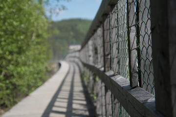 Wooden fence in the park zone next to a river.