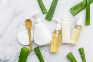 Overhead aloe vera product background with cosmetic bottles and leaves