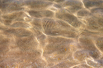 Close-up Sun glare on blue water at sea and on a sandy day on a sunny day