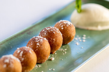 Detail of cinnamon and white chocolate fritters with vanilla ice cream.