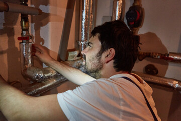 Fitter checks pipe insulation of the heating system