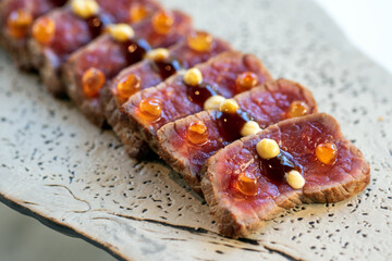 Wagyu beef sirloin tataki slices.