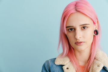 Young white woman with pink hair posing and looking at camera