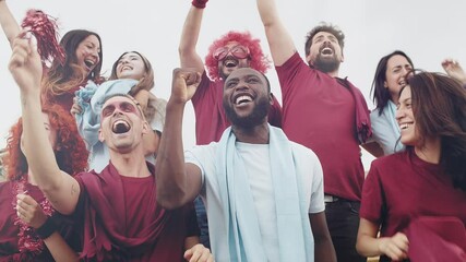 Young fans at stadium before soccer olympic match -Happy multi ethnic sport supporters in red and blue having fun during football world game 