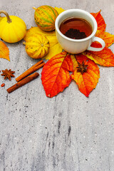 Hot tea with colorful autumn leaves, acorns, cinnamon and rosehip berries