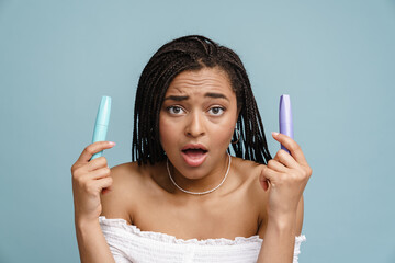 Young black woman expressing surprise while showing mascara