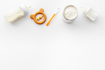 Baby milk in bottle with toy and powdered milk