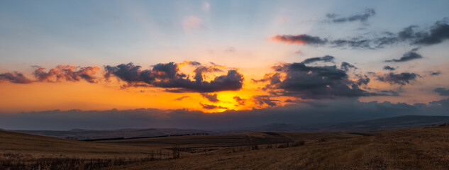 Naklejka na ściany i meble Dramatic sunset over farm fields
